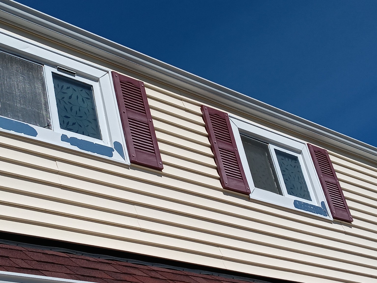 Pair of second-story windows before trim restoration